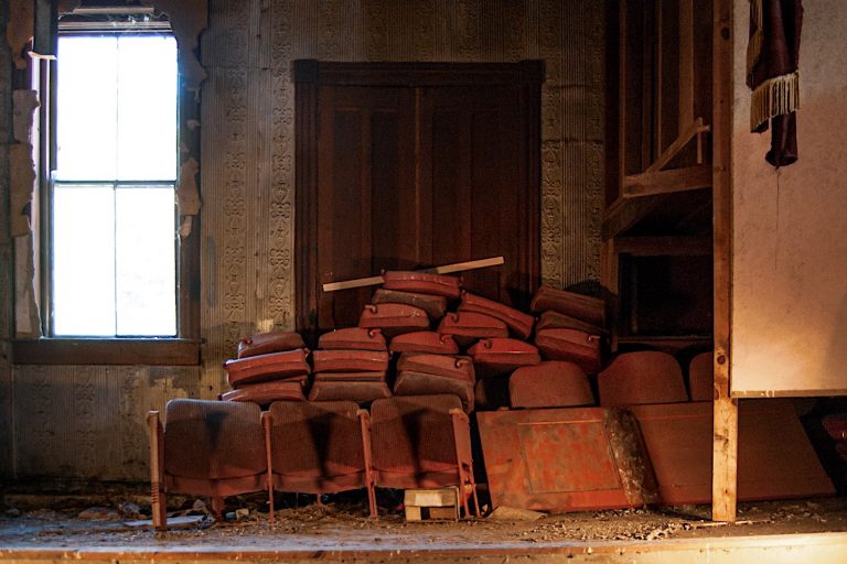 Stage with seats piled in the corner